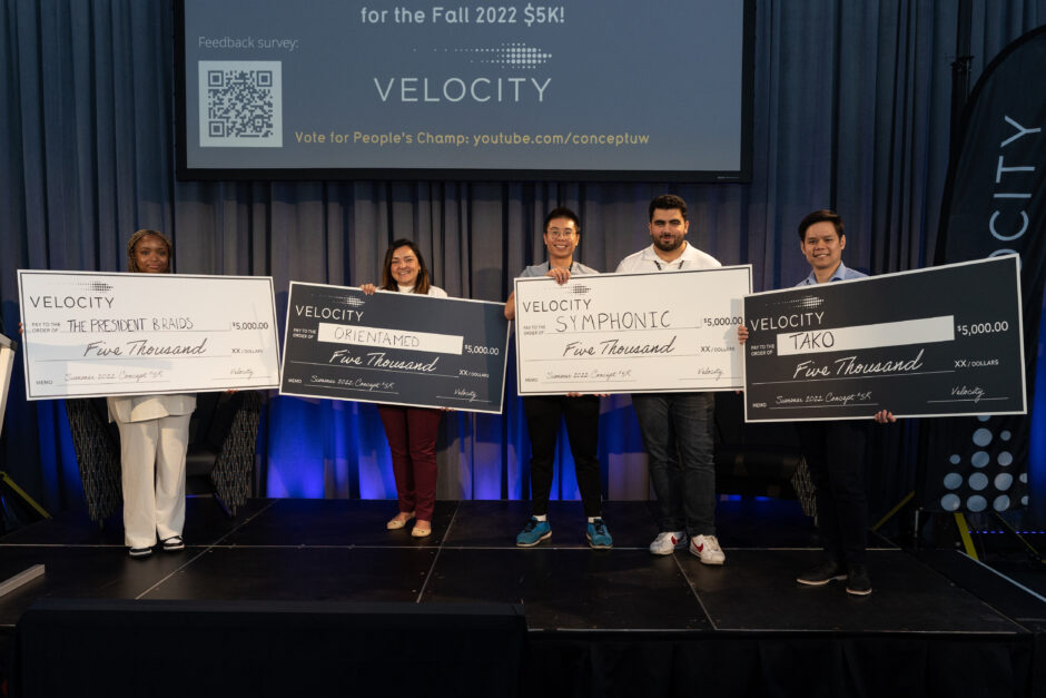 Early-stage University of Waterloo student startup winners of the spring 2022 Velocity $5K stand on stage to accept the large recipient cheques. From left to right: Adanna Amechi (Engineering, Chemical Engineering) of The President Braids; Glaucia Melo dos Santos, (Math, Computer Science) of OrientaMED; Avery Chiu (Engineering, Mechatronics Engineering) u0026 Christopher Samra (Engineering, Mechatronics Engineering) of Symphonic and; an Hung Le (Engineering, Master of Business, Entrepreneurship and Technology) from Tako.