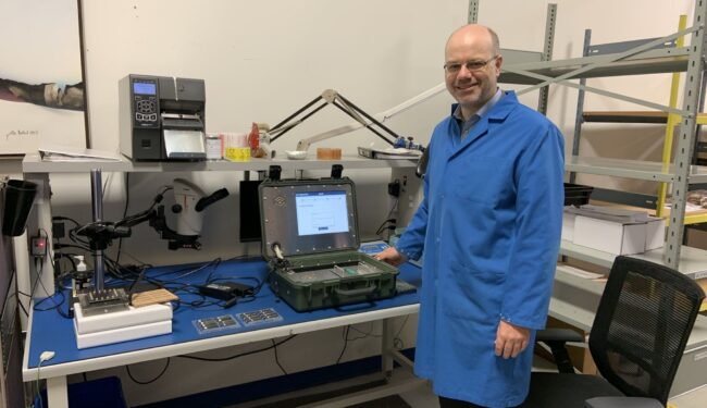 Palitronica co-founder Sebastian Fischmeister stands beside the company's flagship product, the Anvil Checkpoint