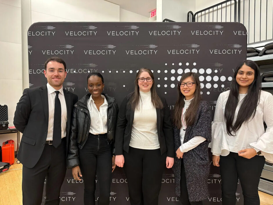 An image showing MetaCycler BioInnovations founders (L-R) Jonathan Parks, Eugenia Dadzie, Nicole LeBlanc, Shirley Wong, Aranksha Thakor. They are standing in front of Velocity branded banner.