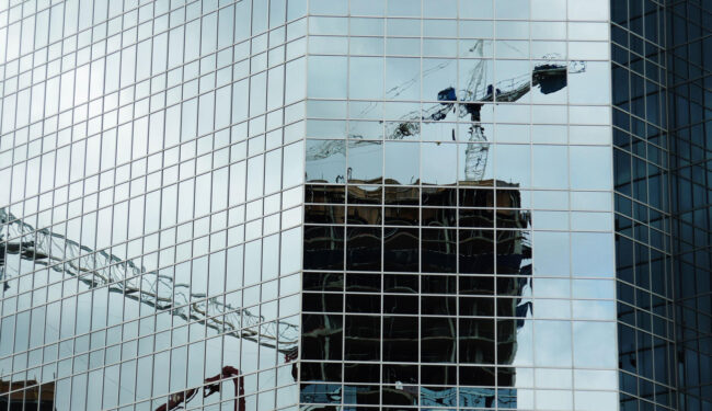 Construction crane reflected in skyscraper