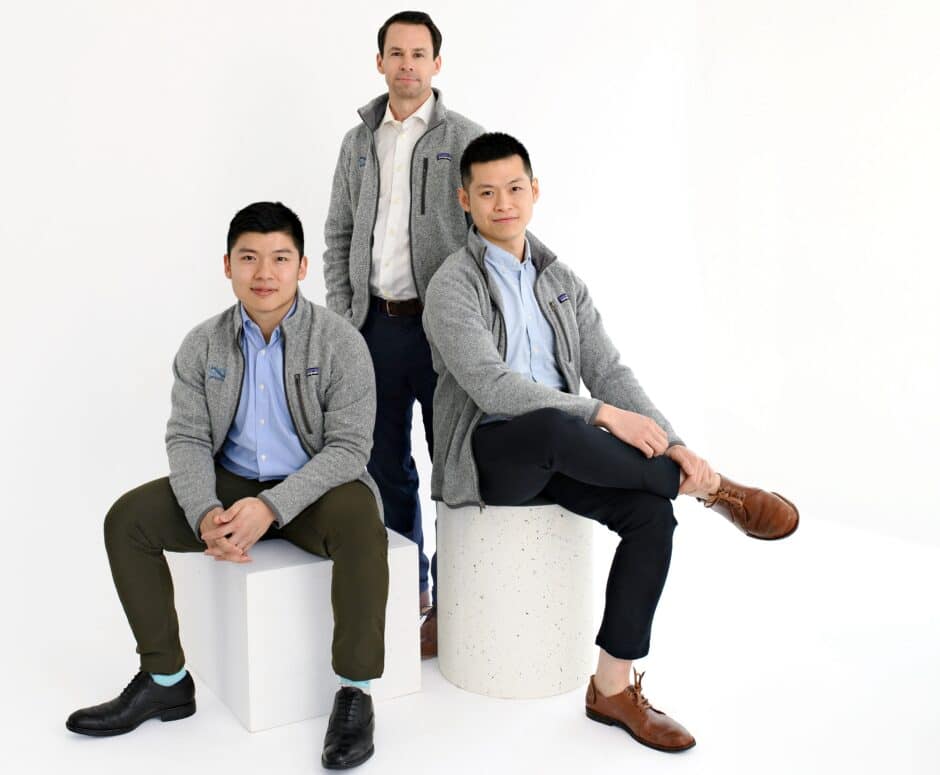 A photo of three founders of Nfinite Nanotech. Two men sitting on white blocks with one man standing in the middle behind them